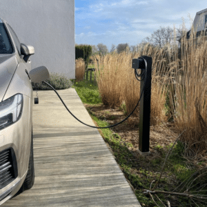 Zwarte laadpaal installatie Wallbox op paal in tuin. Volvo laadt op