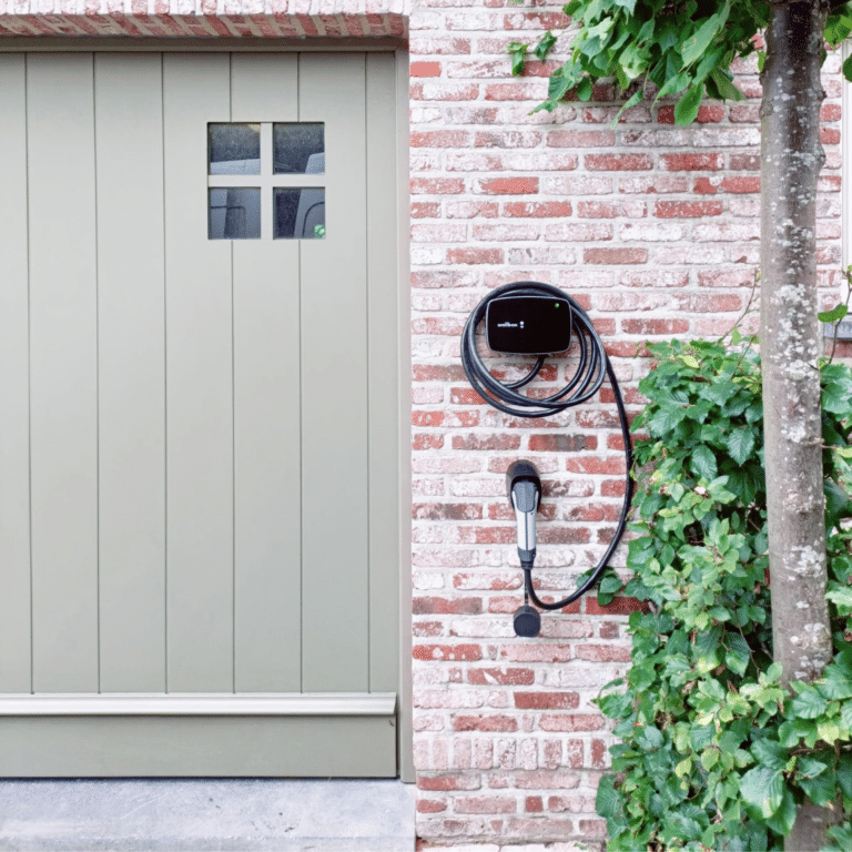 Zwarte laadpaal installatie Wallbox aan buitengevel garage huis