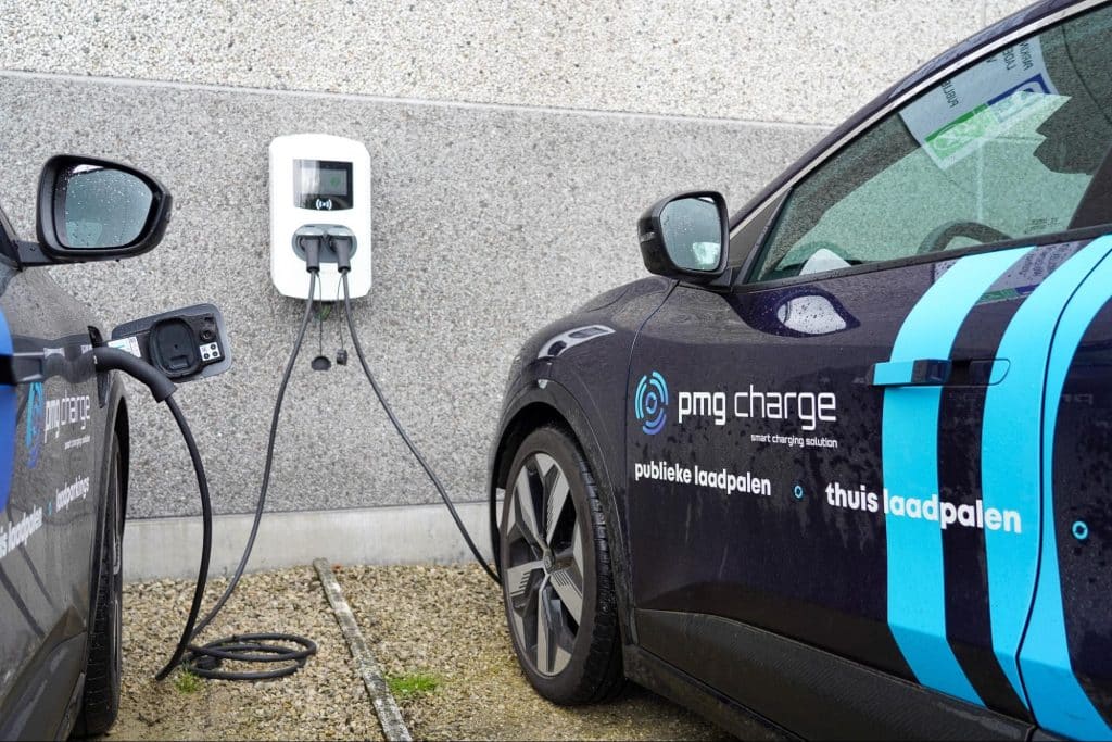 Elektrische wagen van PMG Charge die laadt aan een wandlaadpaal op een privéparking.