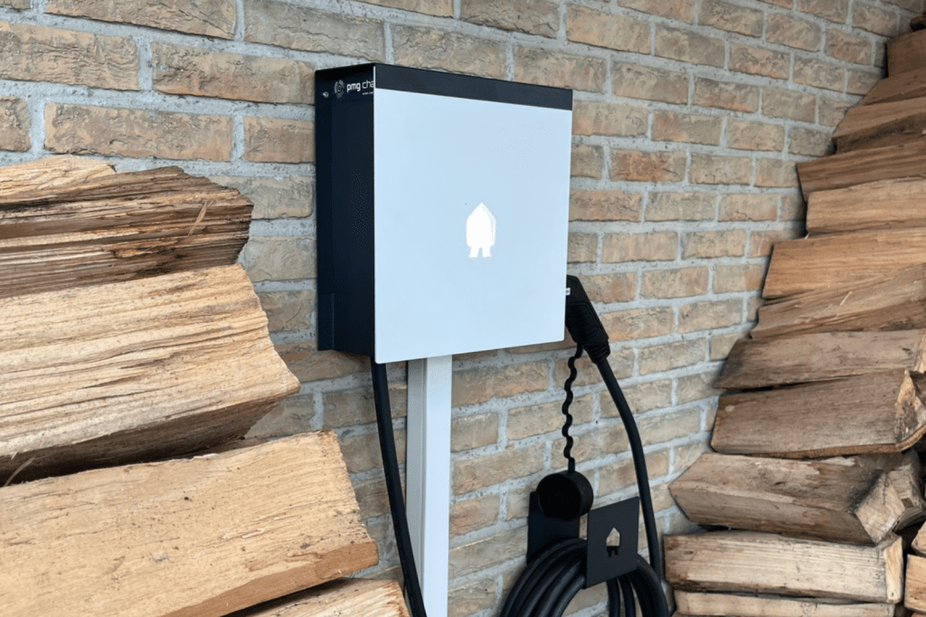 Witte Smappee thuislaadpaal met kabelhouder, geïnstalleerd door PMG Charge tegen een lichte gevel.
