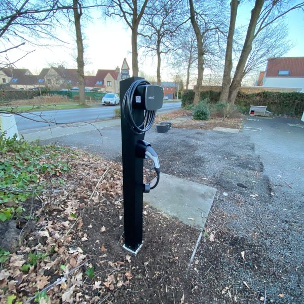 Zwarte laadpaal installatie Wallbox op paal in voortuin thuis.