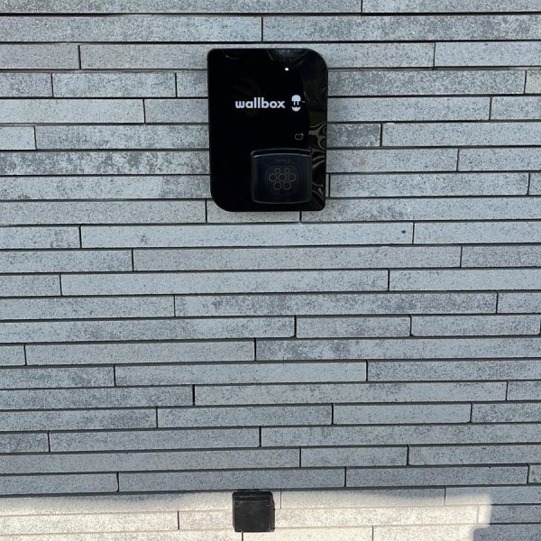 Zwarte laadpaal installatie Wallbox Copper SB - wandmontage buiten grijze gevel
